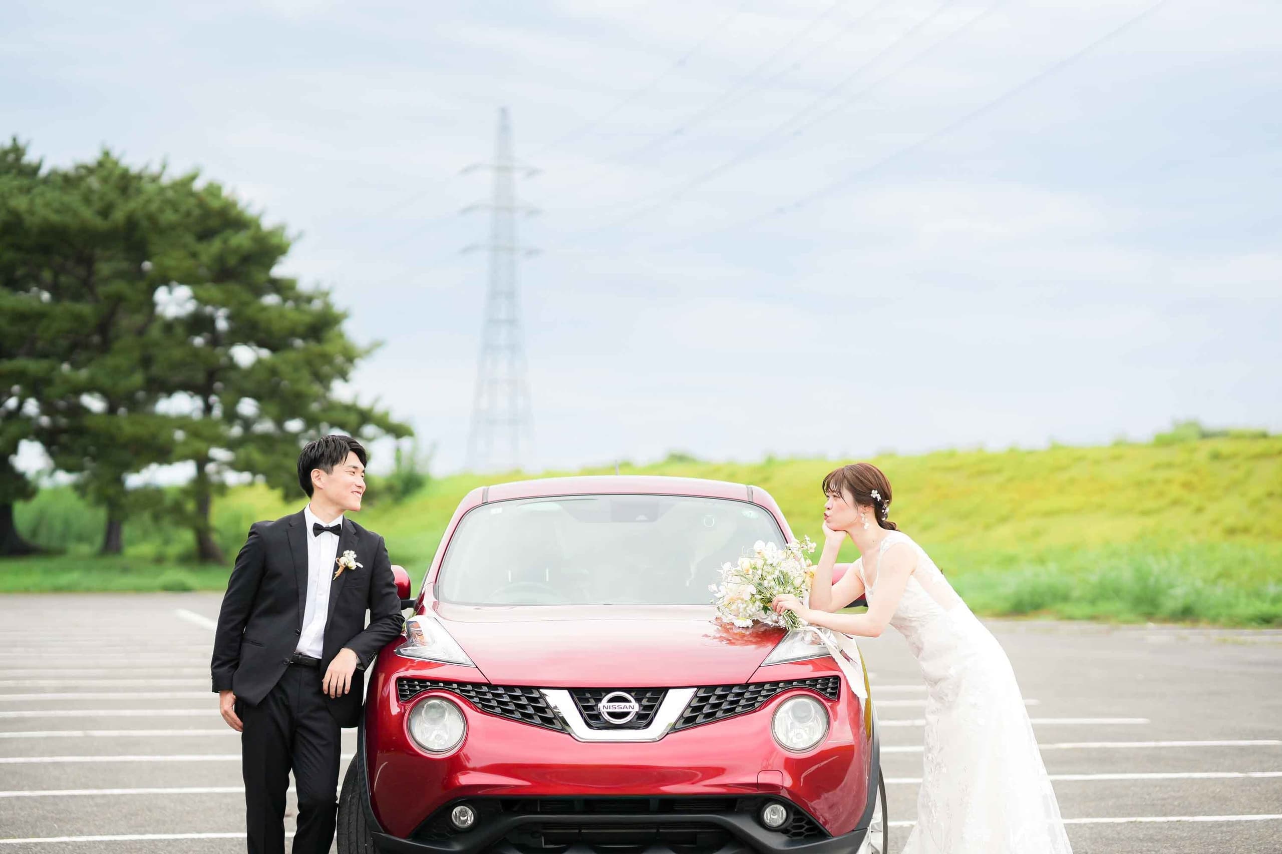 alt="庄内緑地公園でマイカー前撮りする自然な笑顔の新郎新婦"
