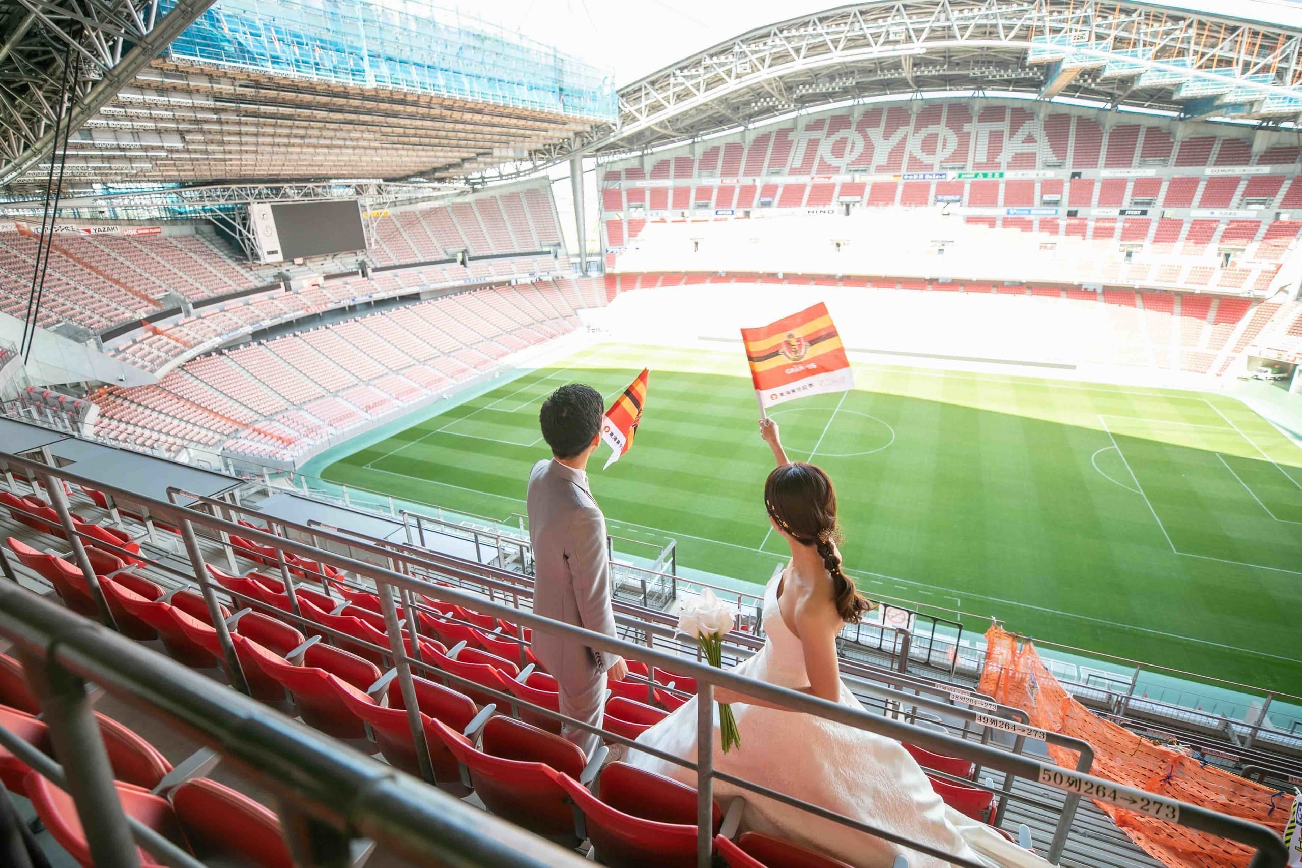 スタジアム前撮りで笑顔の新郎新婦